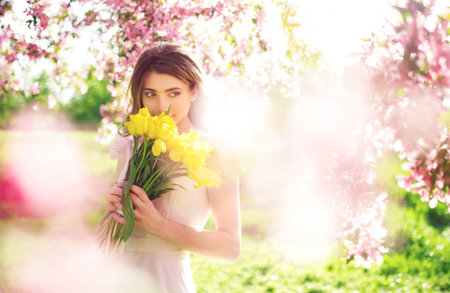 spring style. Beautiful Young Brunette Woman In Nice Spring Dress With A Bouquet Of Tulips.の写真素材