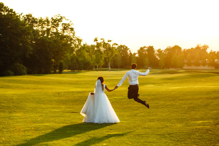 Happy bride and groom go into the sunset. Lovely wedding couple at sunset. Together. Wedding.の写真素材