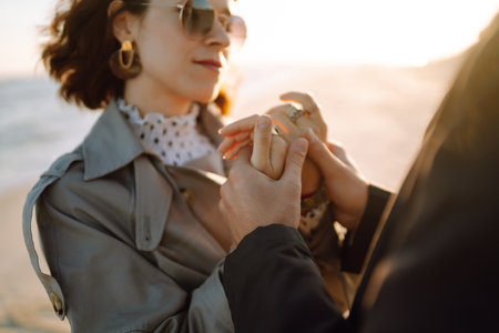 Stylish couple walking and hugging by the sea. Lovely hipster couple enjoying time together.の写真素材