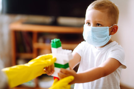 Little boy and mom in medical mask. Mother puts on her baby sterile medical mask. Wearing face mask.の写真素材