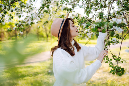 Beautiful young woman near blooming spring tree. Youth, love, fashion, romantic, lifestyle concept.の写真素材