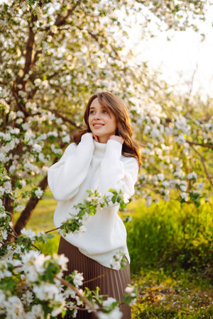 Beautiful young woman near blooming spring tree. Youth, love, fashion, romantic, lifestyle concept.の写真素材