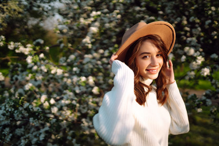 Young woman enjoying scent in blooming spring garden. The concept of relax, travel, spring vacation.の写真素材