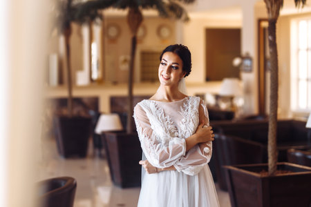 Beautiful bride in fashion wedding dress with a long luxury veil. The stunning young bride is incredibly happy.の写真素材