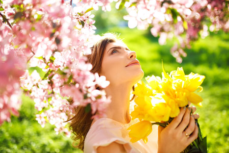 spring style. Beautiful Young Brunette Woman In Nice Spring Dress With A Bouquet Of Tulips.の写真素材