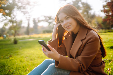 Pretty woman with smartphone having a good time in autumn weekend. People lifestyle concept.の写真素材