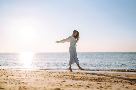 Young woman walking in the sunset on the beach.. Summer time. Travel, weekend lifestyle concept.の写真素材