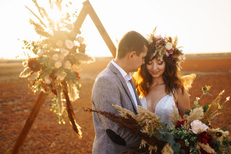 young and beautiful bride and groom enjoy each other. Wedding day in boho style. warm summertime.の写真素材