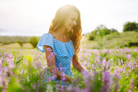 Portrait of beautiful woman in amazing in a blooming field. Nature, vacation, relax and lifestyle.の写真素材