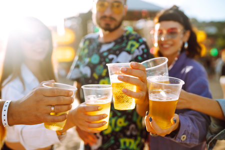 Group of friends with beer dancing and having fun at music festival together. summer beach party.の写真素材