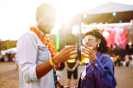 Group of friends with beer dancing and having fun at music festival together. summer beach party.の写真素材