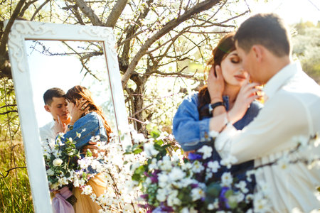 Beautiful loving couple in blooming gardens. wedding concept. Great sunset light. Lovely newlyweds.の写真素材