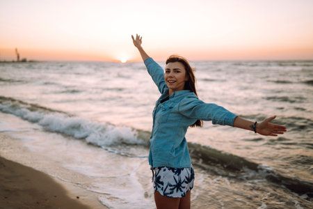 Attractive happy young woman in white t shirt flying hair enjoying her free time at sunset outdoor.の写真素材