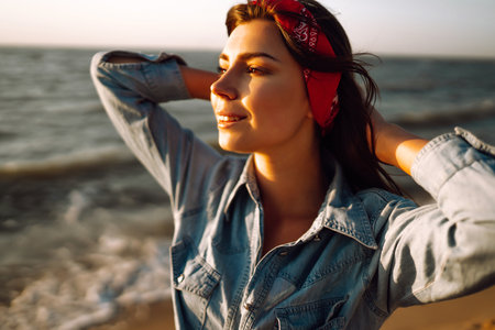 Attractive happy young woman in white t shirt flying hair enjoying her free time at sunset outdoor.の写真素材