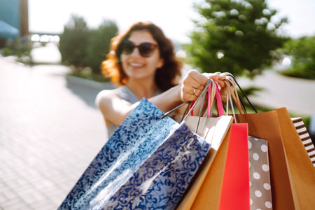 shopping time. Young woman with shopping bags near the mall. Consumerism, sales, purchases.の写真素材