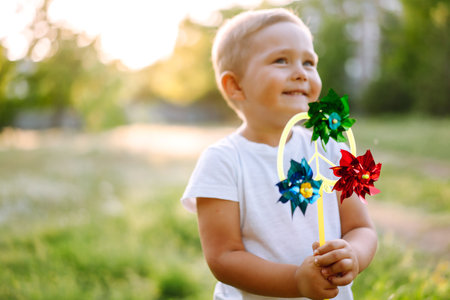 Smiling child with toy in summer park on sunny day. Cute little boy enjoying fresh spring weather.の写真素材