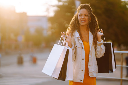 Young woman with shopping bags walking on the street. Sale, shopping and happy people concept.の写真素材