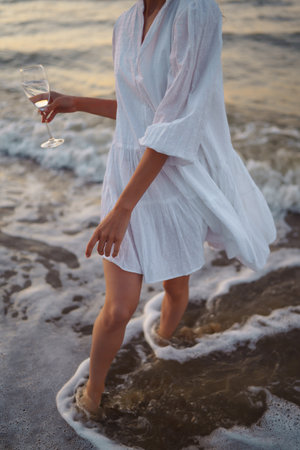 Stylish woman in elegant white dress posing near the sea. summertime. Travel, weekend, relax.の写真素材