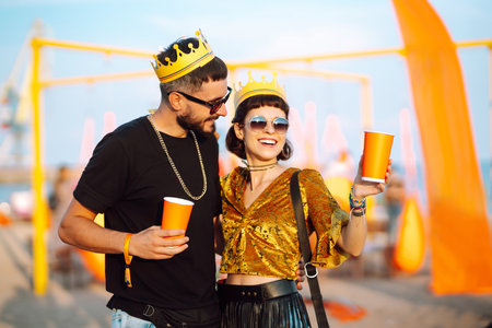 Lovely couple having fun at festival. Young friends with beer at beach party. Summer holidays, holidays.の写真素材