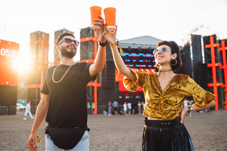 Lovely couple having fun at festival. Young friends with beer at beach party. Summer holidays, holidays.の写真素材