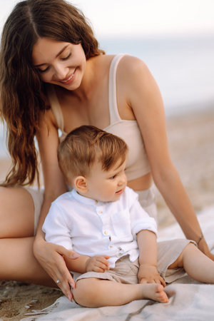 Beautiful mother and child resting on the beach. active lifestyle. happy childhood.の写真素材