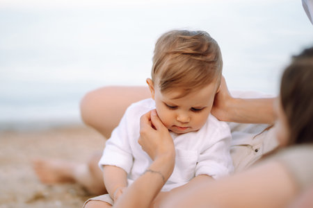 Cheerful young family with little baby boy spending time together on the beach.の写真素材