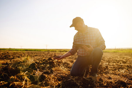 Farmer is checking soil quality before sowing. Agriculture, gardening or ecology concept.の写真素材