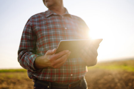Male hands touching soil on the field. Expert hand of farmer checking soil health. Ecology concept.の写真素材