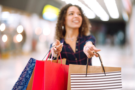Young woman after shopping with shopping bags walks in the mall. spring shooping.の写真素材