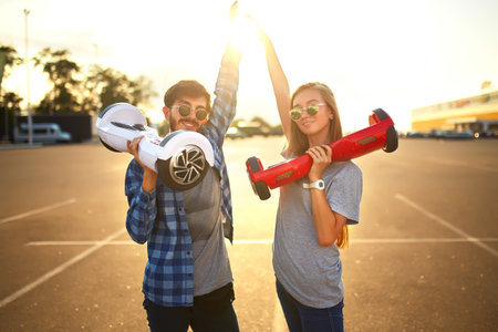 Young man and woman riding on the hoverboard in the park. content technologies. a new movement.
