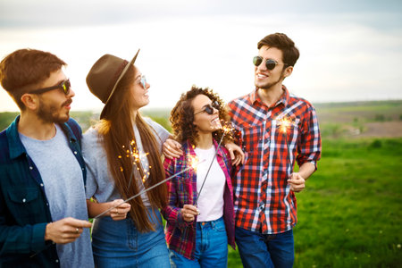 Group of friends enjoying party. People are holding christmas sparklers in their handsの写真素材