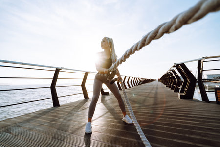 Fitness woman doing sports exercises at the beach pier. healthy lifestyle. Sport, Active life.の写真素材