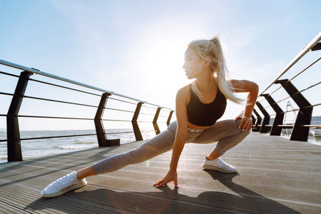Fitness woman doing sports exercises at the beach pier. healthy lifestyle. Sport, Active life.の写真素材