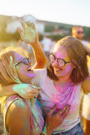 Two beautiful girls have a great time on Holi festival. Spring Break Beach Party. Friendship,...