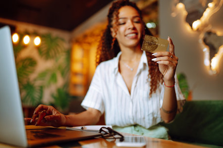 Young woman sitting at cafe making online shopping, using credit card and laptop. online shoppingの写真素材