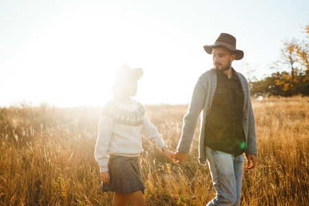 Follow me. Men leads the girl behind him. Lovely hipster couple. couple wearing beautiful hats.の写真素材