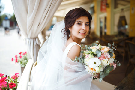 Beautiful bride with wedding flowers bouquet, attractive woman in wedding dress. happy newlywed woman.の写真素材