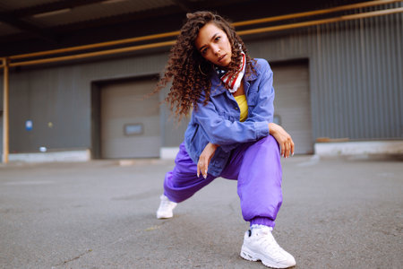 Funky young woman with american bandana dancing alone in the street.Sport, dancing and urban culture