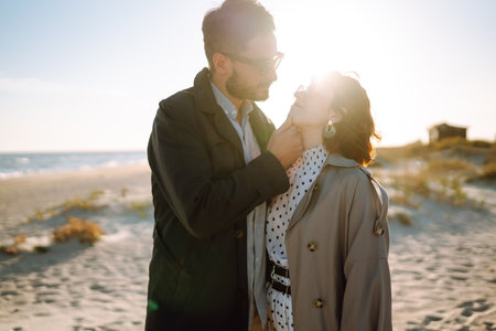 Stylish couple walking and hugging by the sea. Lovely hipster couple enjoying time together.の写真素材
