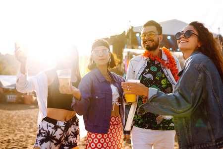 Group of friends with beer dancing and having fun at music festival together.Celebration concept.の写真素材