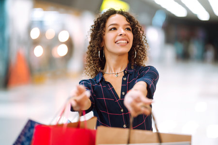 Smiling woman with shopping bags enjoying shopping in the mall.Young woman with packages after shopping.の写真素材