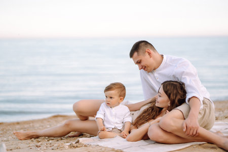 Cheerful young family with little baby boy spending time together on the beach.の写真素材