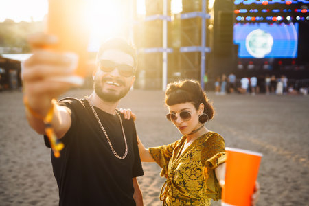 Lovely couple having fun at festival. Young friends with beer at beach party. Summer holidays,...