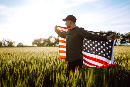 Man hold american USA flag. Patriot raise national american flag. Independence Day, 4th July.の写真素材