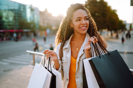 Young woman with shopping bags walking on the street. Sale, shopping and happy people concept.の写真素材