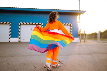 African American lesbian woman holding LGBT rainbow flag. The concept of happiness, freedom and love for same-sex couples.の写真素材
