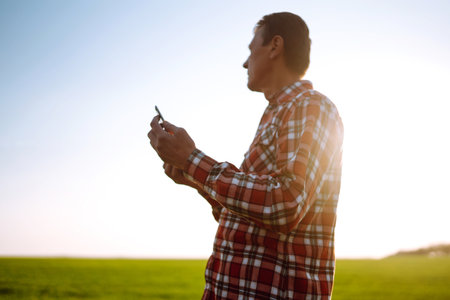 Farmer working with digital tablet in field at sunset. Checking wheat field. agriculture concept.の写真素材