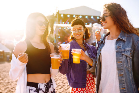 Girlfriends drinking beer and having fun at music festival. friendship and celebration. beach party.の写真素材