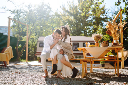 Beautiful wedding couple laugh and kiss relaxing in rv, camping in a trailer. romantic moment.の写真素材