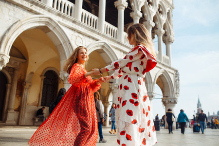 Mom and daughter in fashionable dresses walk around Venice. Lifestyle, travel, tourism.の写真素材